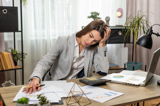Depressed desperate businesswoman feeling worried about financial problem doing paperwork. Stressed freelancer looking frustrated thinking of money debt, budget loss, bankruptcy at home office table