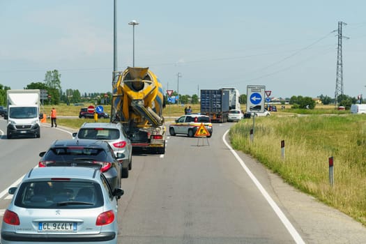 Caravaggio, Italy - June 7, 2023: An accident at the roundabout involving a truck and a car, a traffic jam has formed, the police are working.