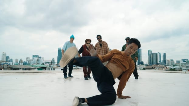 Professional break dance team practice B-boy dance while multicultural friends at rooftop. Young modern dancing group doing hip hop movement. Style,fashion,action. Outdoor sport 2024. Endeavor.