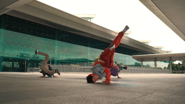 Group of happy hipster or street dancer doing freeze pose in front of mall. Funny energetic break dancer practice b-boy step dancing with friends. Outdoor sport 2024. Street dancer concept. Sprightly.