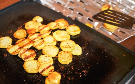 Potatoes cut to small circles, seasoned with spices, grilled on electric grill