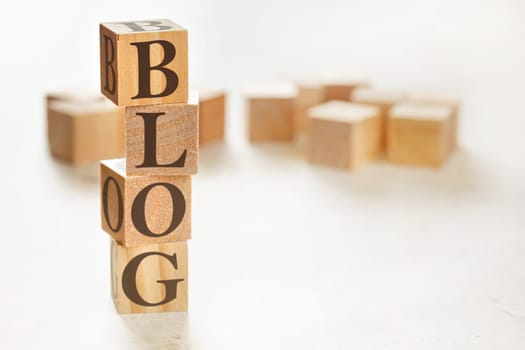 Four wooden cubes arranged in stack with word BLOG on them, space for text / image at down right corner