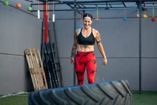 Happy strong woman proud while working out in the gym using a wheel