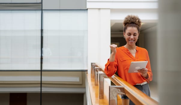 Young busy African business woman executive working on laptop making call at office.