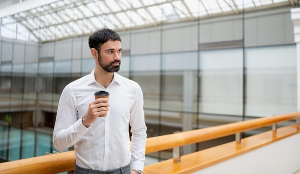 Smiling mature businessman holding a smartphone in an office. High quality photo