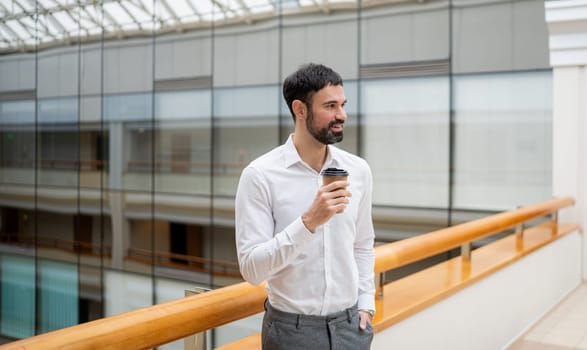 Smiling mature businessman holding a smartphone in an office. High quality photo