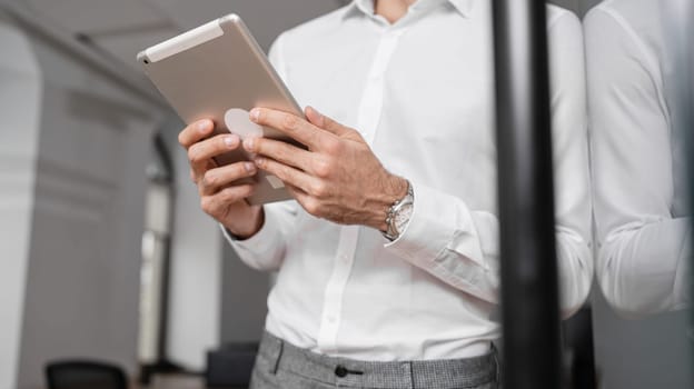 Smiling mature businessman holding a smartphone in an office. High quality photo