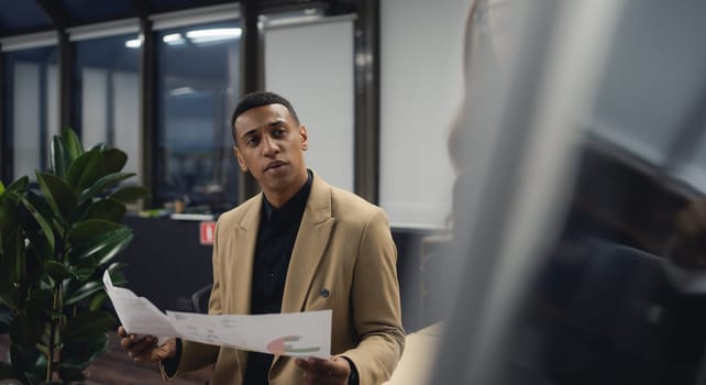 Businessman looking at the camera while standing alone in a modern workplace. High quality photo