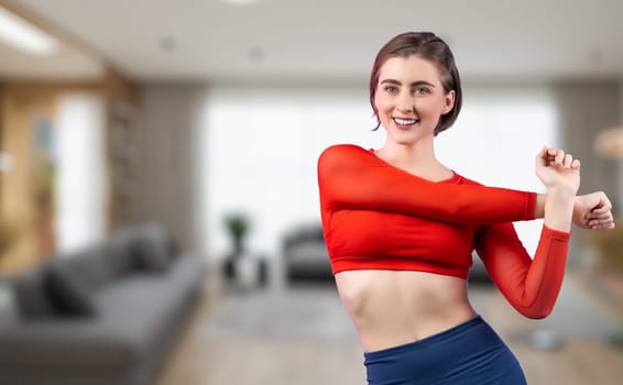 Athletic and sporty woman doing warmup and stretching before home body workout exercise session for fit physique and healthy sport lifestyle at home. Gaiety home exercise workout training concept.
