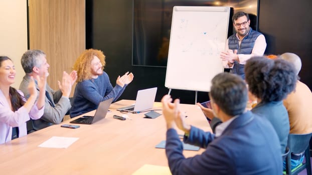 Group of coworkers applauding during a colleague presentation of a project