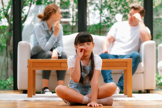 Stressed and unhappy young girl crying and trapped in middle of tension by her parent argument in living room. Unhealthy domestic lifestyle and traumatic childhood develop to depression. Synchronos