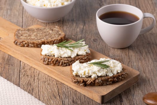 Homemade rye bread with cottage cheese in a plate and coffee. Healthy breakfast concept...