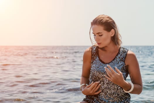 Woman travel sea. Young Happy woman in a long red dress posing on a beach near the sea on background of volcanic rocks, like in Iceland, sharing travel adventure journey