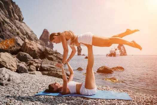 Woman sea yoga. Back view of free calm happy satisfied woman with long hair standing on top rock with yoga position against of sky by the sea. Healthy lifestyle outdoors in nature, fitness concept.