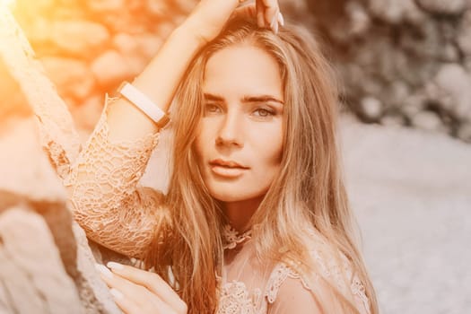 Woman travel sea. Young Happy woman in a long red dress posing on a beach near the sea on background of volcanic rocks, like in Iceland, sharing travel adventure journey