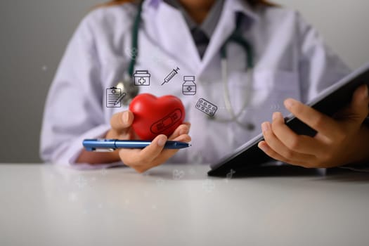 Doctor or cardiologist holding red heart shape in hand. Medical and health insurance concept.