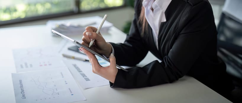 Businesswoman in office using tablet computer, audit documents and financial analysis, business people concept.