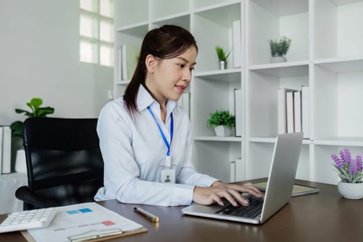 Businesswoman analyzing marketing strategy on laptop, typing work on laptop.