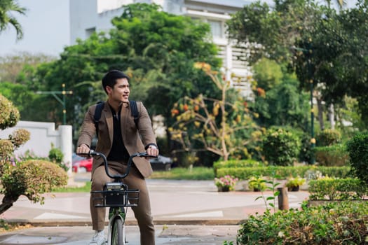 A man in a suit is riding a bicycle in front of a row of parked cars. Concept of urban life and the man's determination to get to his destination