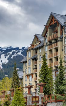 Residential building on snow-capped mountains background.