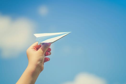 hand holding paper airplane in the sky, Taking flight, Dreams and imagination, concept of freedom.