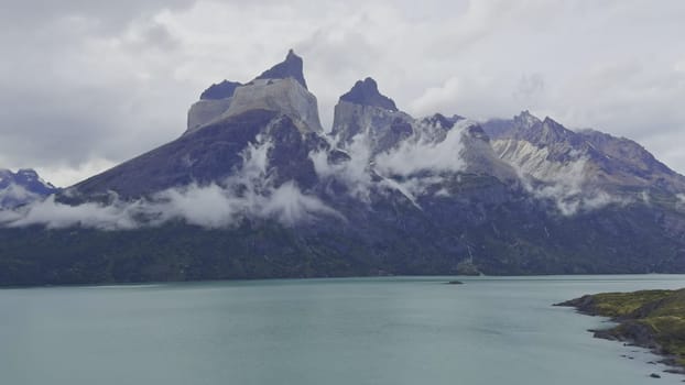 Time-lapse of clouds over a lake with Cuernos del Paine mountain in the background.
