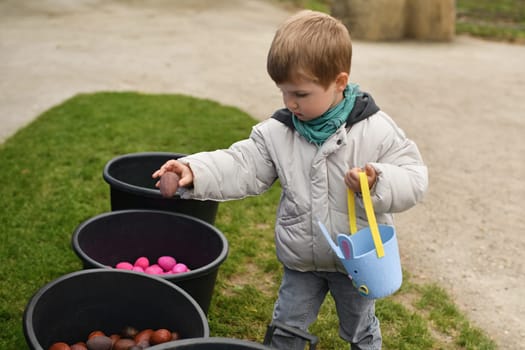 Boy collects the eggs in a basket Easter