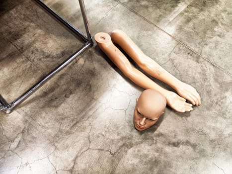 Disassembled Mannequin on Concrete Floor. Mannequin parts scattered on polished surface