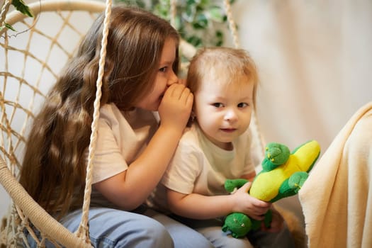 Happy time concept. Girls Sisters in chair and having fun. Female Preschooler and teenager playing and relaxing in room