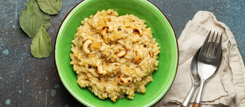 Ven Pongal (Khara Pongal), traditional Indian savoury rice dish made during celebrating Pongal festival, served in bowl top view on concrete rustic background.