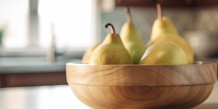 Pears in a bowl on the kitchen table on a blurred background