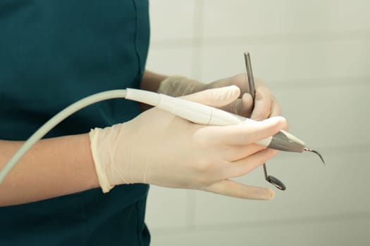 Dentist in gloves holding his tools during patient examination