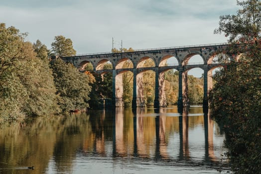 Railway Bridge with river in Bietigheim-Bissingen, Germany. Autumn. Railway viaduct over the Enz River, built in 1853 by Karl von Etzel on a sunny summer day. Bietigheim-Bissingen, Germany. Old viaduct in Bietigheim reflected in the river. Baden-Wurttemberg, Germany. Train passing a train bridge on a cloudy day in Germany