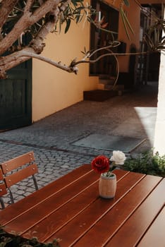 Empty cafe terrace with white table and chair. exterior of the cafe restaurant. interior Street cafe. Cozy street with flowers and French-style cafe table. Decor facade of coffeehouse with bike. Table on a summer terrace with cake and teapot. Garden table and chairs