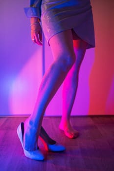 Woman legs closeup in stokings with neon color background