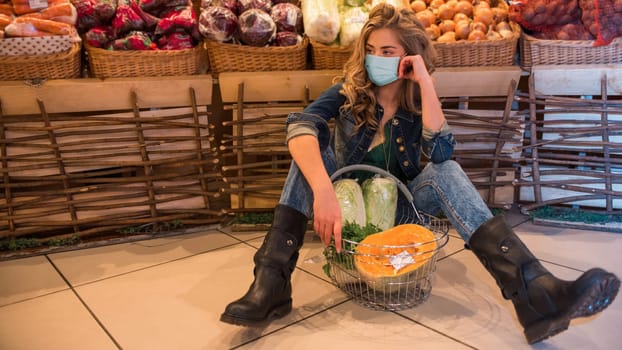 The young pretty woman in face blues mask is shopping in supermarket