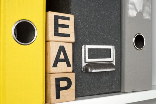 Shelf with folders and cubes with letters. EAP Employee Assistance Program concept.