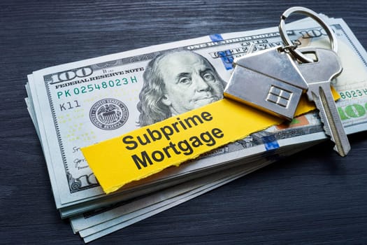 Subprime mortgage concept. Stack of cash and key.