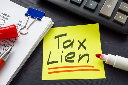 Tax lien concept. The inscription is on sticker lying near the notepad.