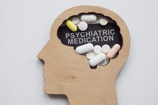 Model of head with pills and an inscription psychiatric medication.