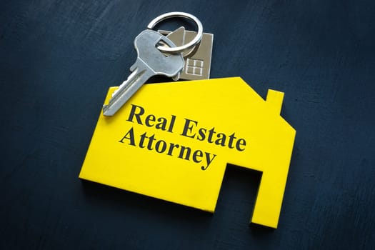 Key and sign Real estate attorney with an inscription in the shape of house.