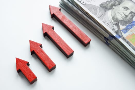 Growing graph of arrows and cash as symbol of personal savings and income.