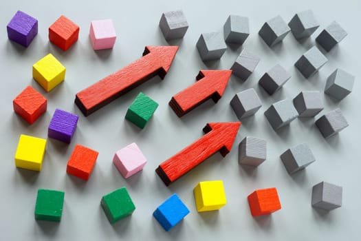Gray cubes, arrows and colored ones as symbol of diversity and inclusion.