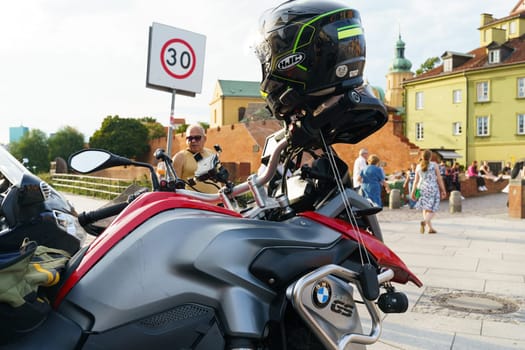 Warsaw, Poland - August 6, 2023: Detailed view of the BMW R1200 motorcycle. On the handlebars is a motorcyclist's helmet.