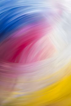 A vibrant and blurry picture of a colorful swirl featuring shades of purple, pink, violet, and magenta. The artful pattern also includes hints of electric blue, reminiscent of a sky backdrop
