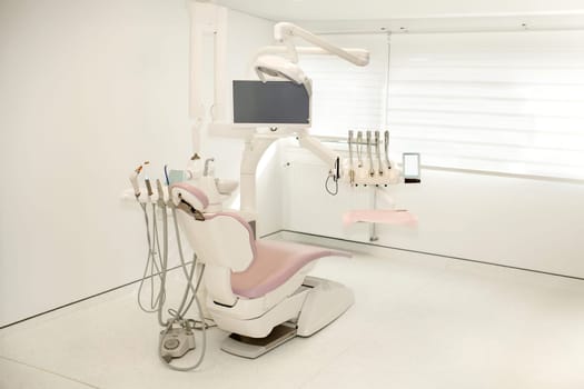 Pink dental chair in a modern dental cabinet