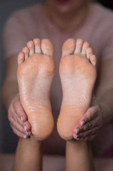 Close-up of a woman's feet massage. Vertical photo