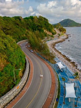 car driving on the curved road of Thailand. road landscape in summer. it's nice to drive on the beachside highway. Chantaburi Province Thailand, couple walking on the road