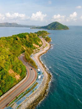 car driving on the curved road of Thailand. road landscape in summer. it's nice to drive on the beachside highway. Chantaburi Province Thailand, beautiful road alongside the ocean at sunset