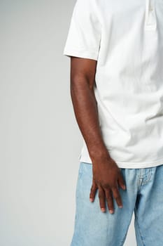 A detail-oriented capture showcasing casual fashion, a person is dressed in a classic white t-shirt paired with light blue denim jeans.
